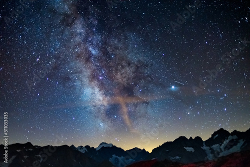 Droga Mleczna wygina się gwiaździste niebo w Alpach, Massif des Ecrins, ośrodek narciarski Briancon Serre Chevalier, Francja. Panoramiczny widok na wysokie góry i lodowce, fotografia astro, obserwacja gwiazd