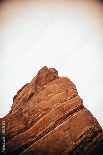 big red rock with white sky