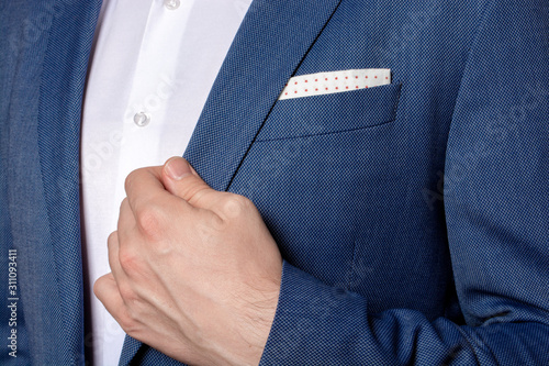 Male hand of businessman holding the edge of his classic blue blazer 