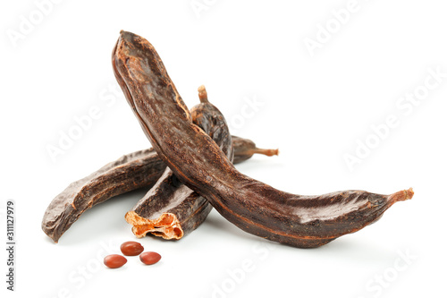 Carob carob fruit and seeds on white background. Isolate. Organic carob beans, a healthy alternative to cocoa.