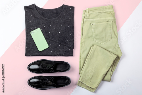 Casual female outfit flat lay on pink and white background