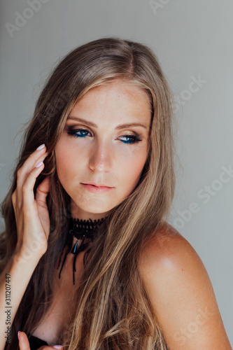 BLONDE GIRL WITH BLUE EYES MAKEUP ON WHITE BACKGROUND