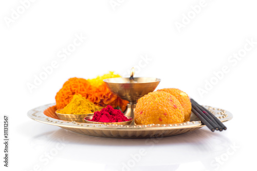 Beautifully Decorated Pooja Thali for festival celebration to worship, haldi or turmeric powder and kumkum, flowers, scented sticks in brass plate, hindu puja thali