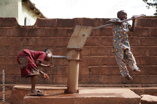 African Children Playing At the Village Water Pump