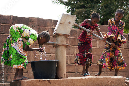 African Children At A Public Borehole Fetching Water For Their Families