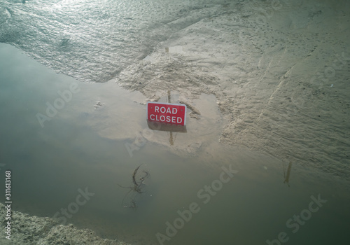 Road closed sign under water