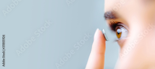 Contact lens on index finger near beautiful female face. text area