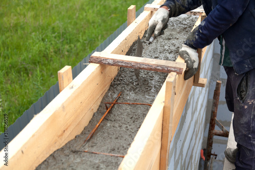 Worker levels concrete in formwork using a trowel