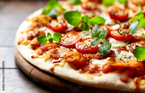 Tasty vegetarian pizza with cherry tomatoes, mozzarella cheese and fresh oregano. Close up.