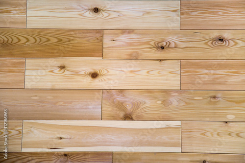 Background of planed planks of larch floor with a beautiful pattern of the structure of trees knots. Design backgrounds texture construction.