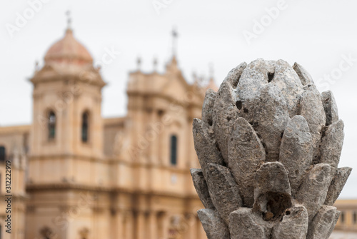 Baroque ornament in Noto (Sicily, Italy); in the background blurred view of the cathedral