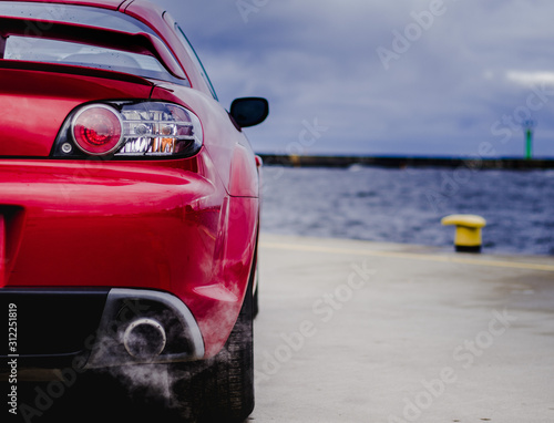 Red sports car in harbor 