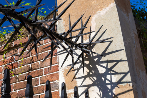 Within the beautiful historic district of Charleston, South Carolina are many antebellum and Georgian mansions. Detail of a spiked iron gate and fence the of a historic home are seen here.