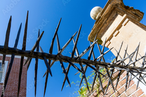 Within the beautiful historic district of Charleston, South Carolina are many antebellum and Georgian mansions. Detail of a spiked iron gate and fence the of a historic home are seen here.