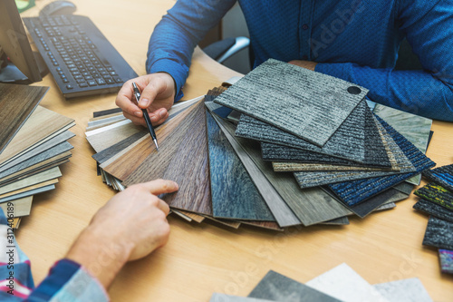 interior design - customer choosing floor material from samples at flooring shop