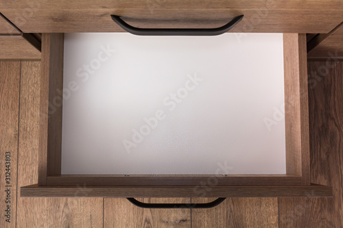 Top view of empty open wooden drawer