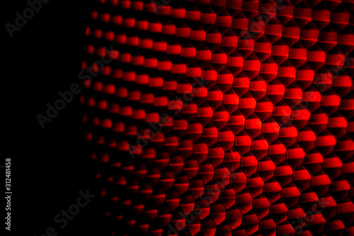 Closeup honeycomb grid texture with red light. Red and dark metal hexagon shaped pattern abstract background. Light modifier equipment. Metal honeycomb. Futuristic pattern. Honey grid cells network.