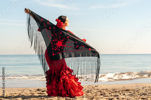 Young Spanish woman dancing flamenco on the beach