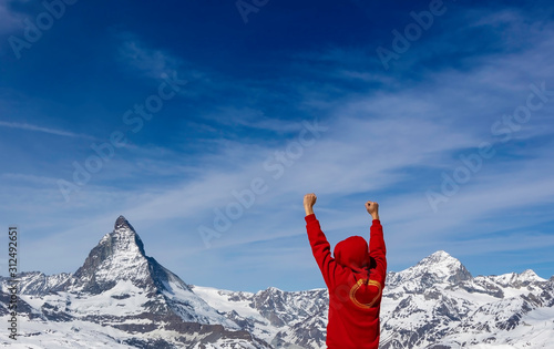 Success image which young man show double fist up with blue sky at Matterhorn in Zermatt ,Switzerland