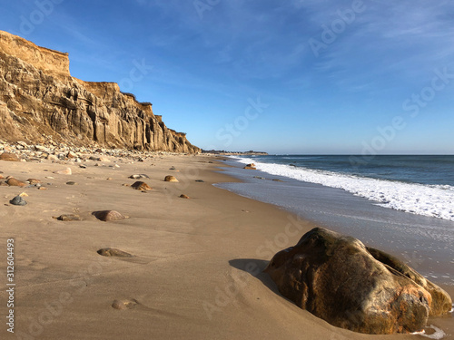 A Large Boulder in the Foreground with Cliffs in the Background on the Beach in Montauk, Long Island, New York.