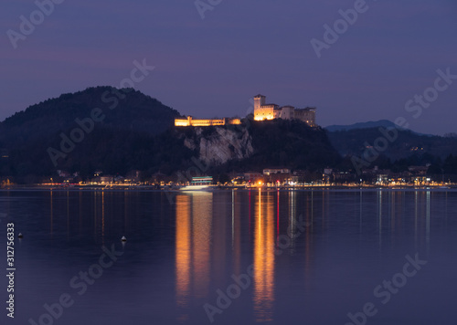 the Lombard shore of Lake Maggiore and the Borromea fortress at night time viewed from Arona.Italy