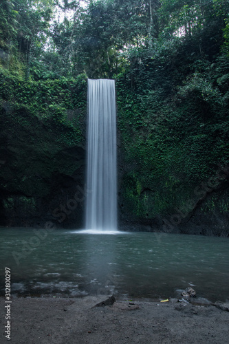 Perfect Bridal Veil Waterfall In The Middle Of A Thick Green Forest. Tibumana Waterfall in Ubud, Bali, Indonesia