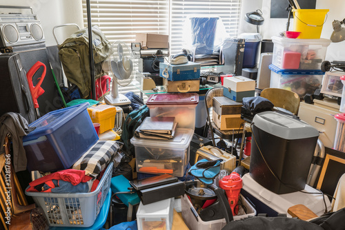 Hoarder room packed with boxes, electronics, business equipment, household objects and miscellaneous junk.