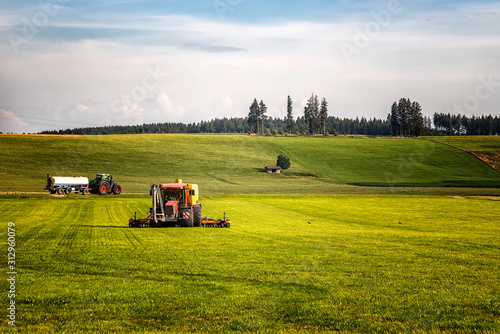 Application of manure on arable farmland with the heavy tractor who works at the field in Germany