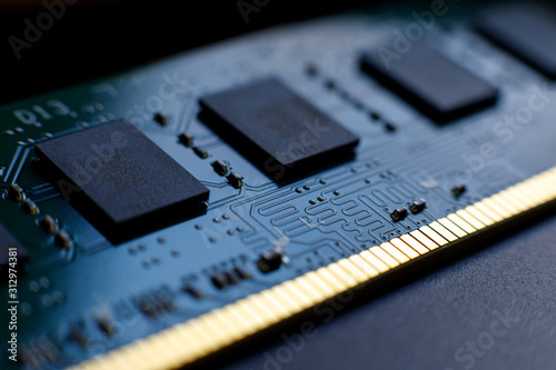 Contacts, connecting tracks and microchips of a computer RAM Random Access Memory modules close-up for electronic design. Selective focus.