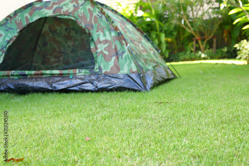 green grass garden field with tent camping on lawn of campsite trip travel in nature