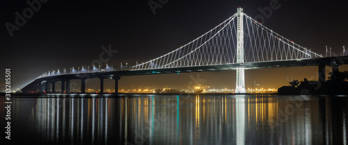 Eastern span of San-Francisco-Oakland Bay Bridge panoramic view at night. Shot from Treasure Island, San Francisco, California, USA.