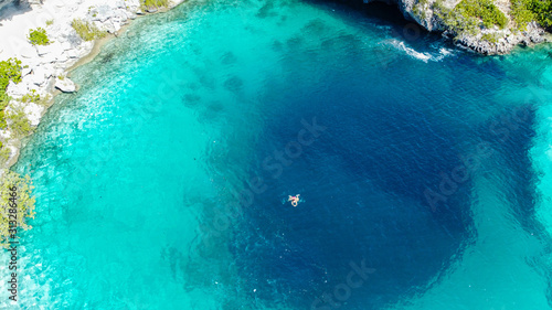 Frau schwimmt über tiefe Stelle im Ozean. Dean's Blue Hole auf Long Island, Bahamas.