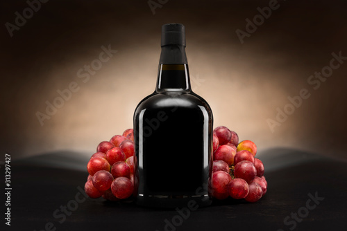 Czarna butelka czerwonego wina z winogronami packshot