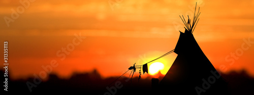 An American Indian tipi (teepee) against an evening sunset.