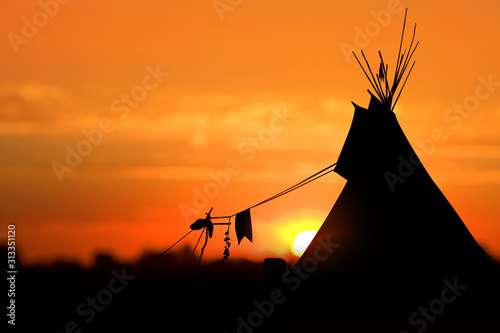 An American Indian tipi (teepee) against an evening sunset.