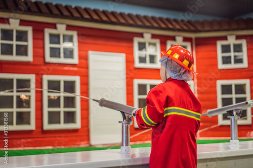 Expressive cute toddler with fireman outfit playing fireman
