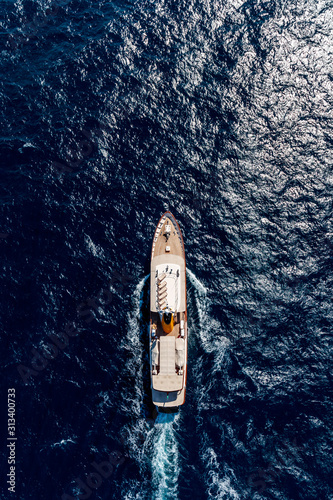 Aerial vertical shot of a boat sailing on the sea