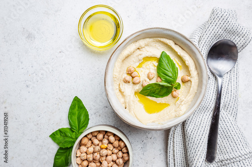 Bowl of healthy homemade creamy chickpea hummus dip with olive oil, top view