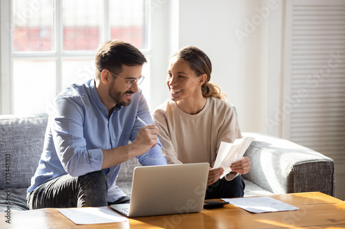 Happy young couple pay bills using online banking