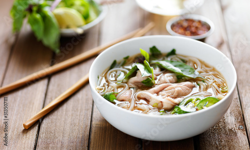 vietnamese beef pho with chopsticks on wooden table