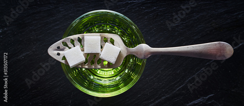 absinthe with sugar cubes and spoon flat lay composition