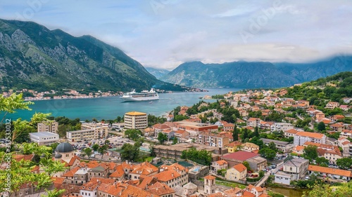 The picturesque town of Kotor, Montenegro, and its long bay and surrounding mountains, as a cruise ship enters the sheltered harbor.