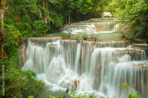 Breathtaking waterfall at deep forest, Tropical rain forest or evergreen forest with waterfall, Erawan waterfall located Kanchanaburi Province, Thailand