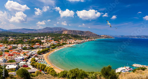 Greek holidays, beautiful Kalyves village with turquoise sea in Crete island, Greece. View of Kalyves beach, Crete. Seagulls flying over the beach in Kalyves, Crete, Greece