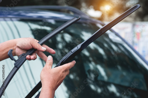 Mechanic replace windshield wipers on car. Replacing wiper blades