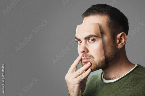 Be Yourself. Handsome man holds a mask of his face. Copy space.