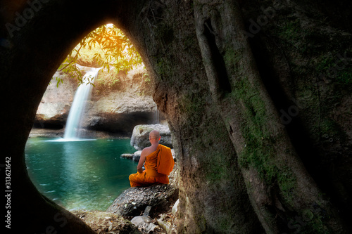 Buddha monk practice meditation at waterfall