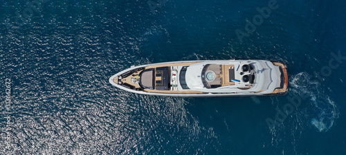 Aerial drone ultra wide photo of luxury yacht with wooden deck docked near port of Port of Fontvieille in deep blue sea, Monaco, France