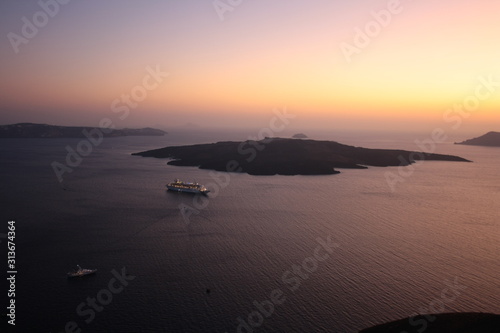 Widok na wyspę Nea Kameni, morze i kalderę Santorini o zachodzie słońca