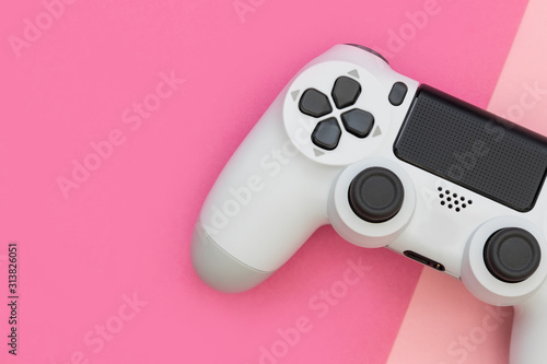Video game gaming controller on pink color background top view